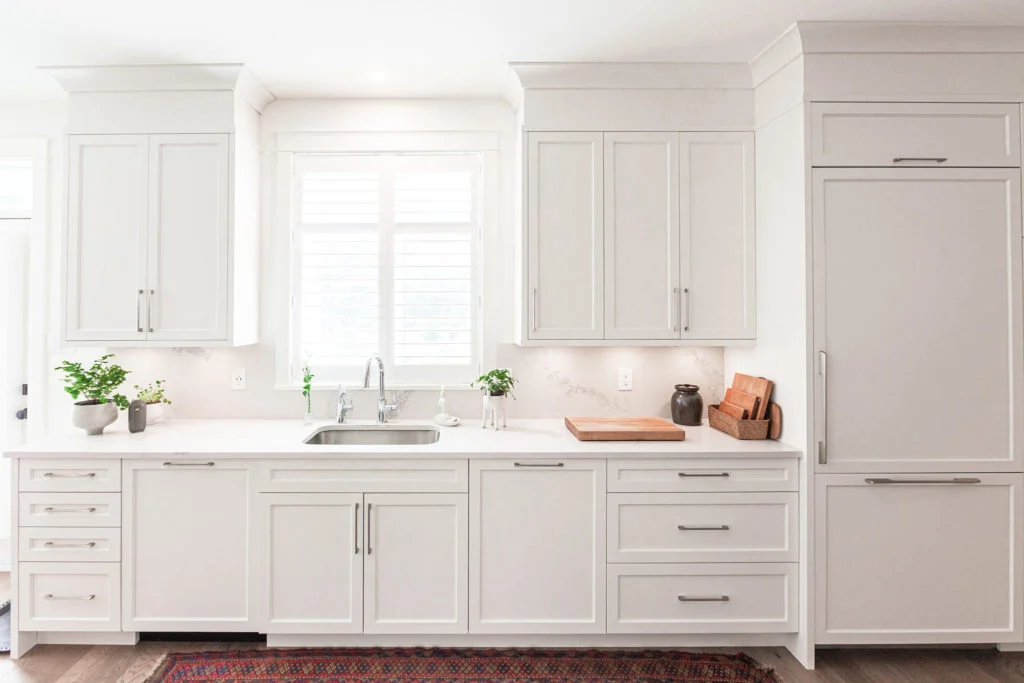 White kitchen with silver hardware that extends to the ceiling