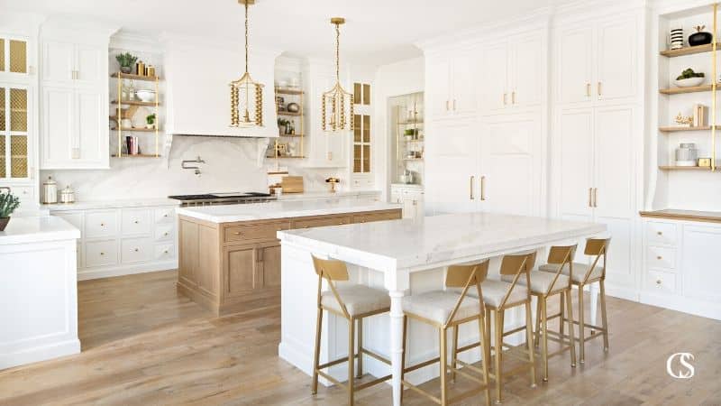 White kitchen with gold accents and large double islands