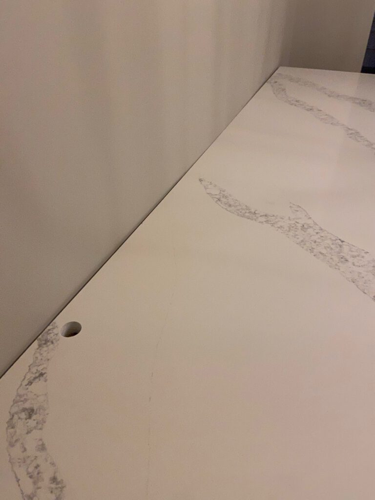 Countertop installed against bowed wall with gap