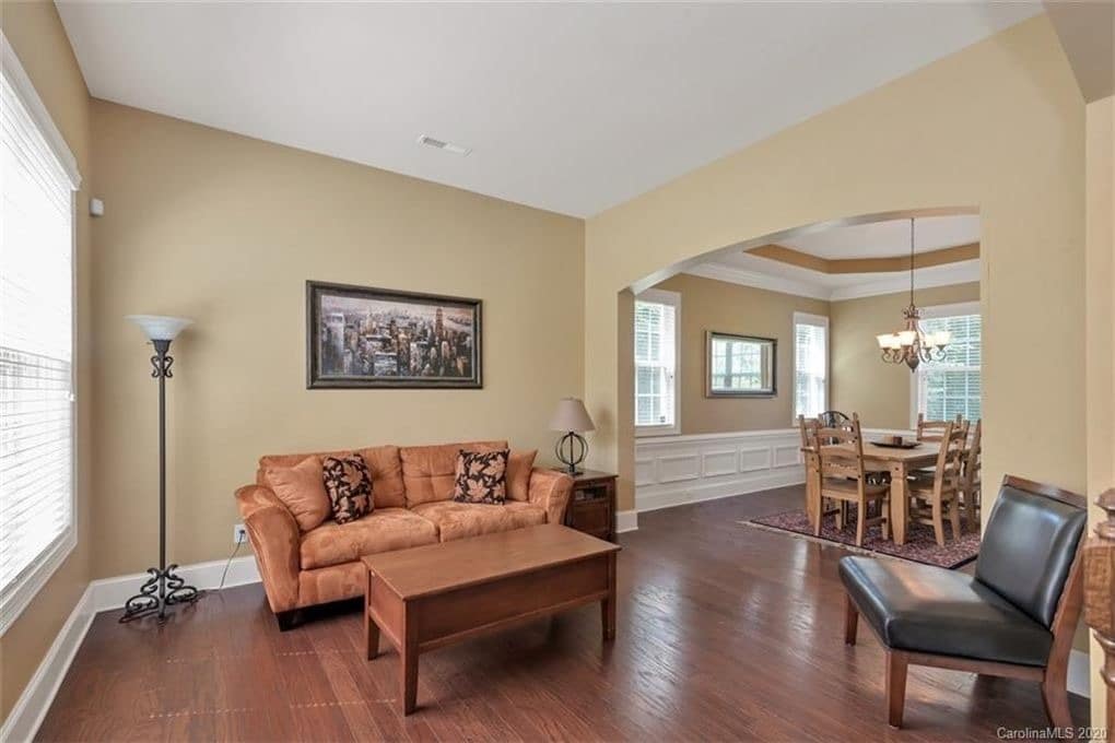 Sitting Room With Beige Walls, Dark Wood Floors And No Overhead Light