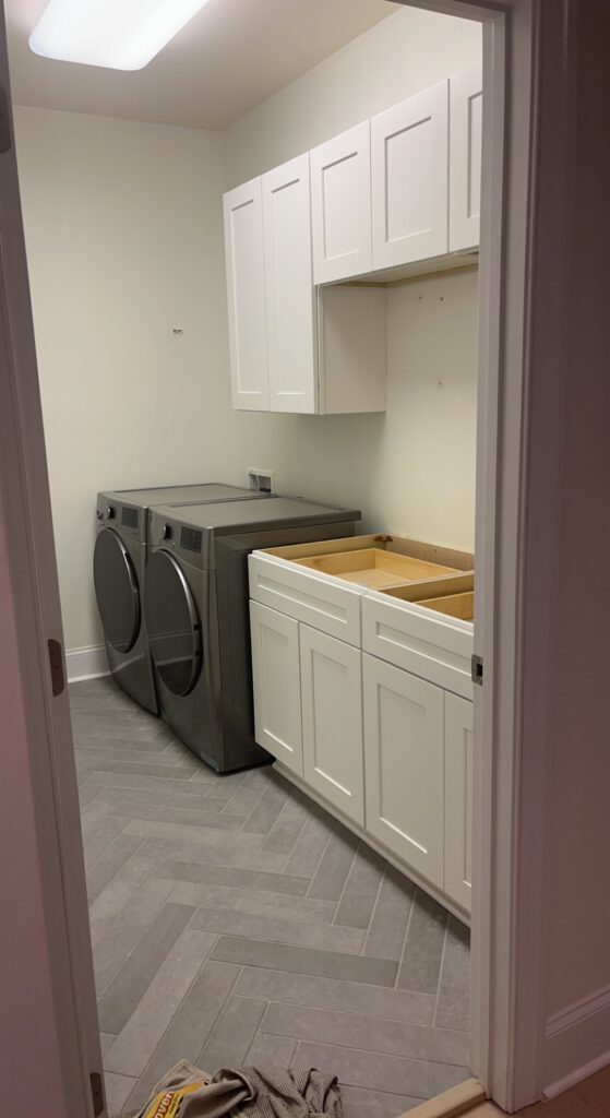 White Cabinets Being Installed In A Laundry Room