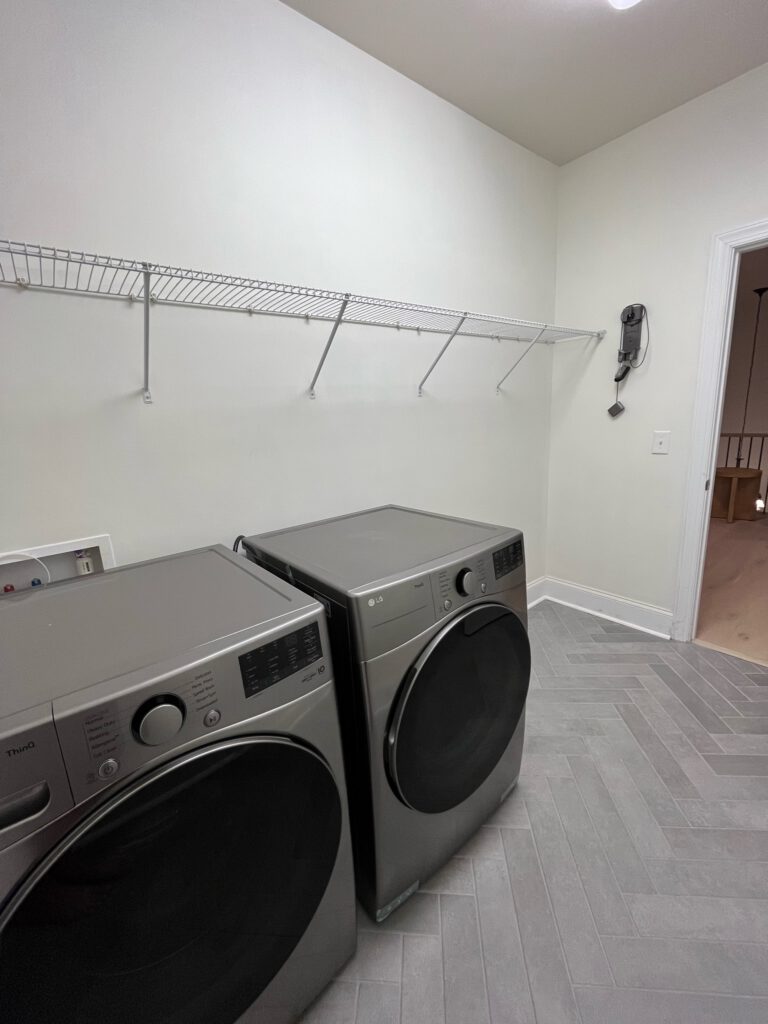 Herringbone tile with new washer and dryer