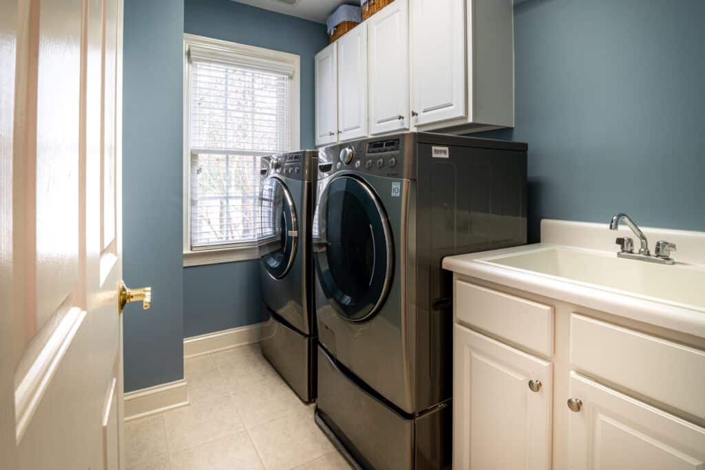 Side-by-side front loading washing machines on risers.