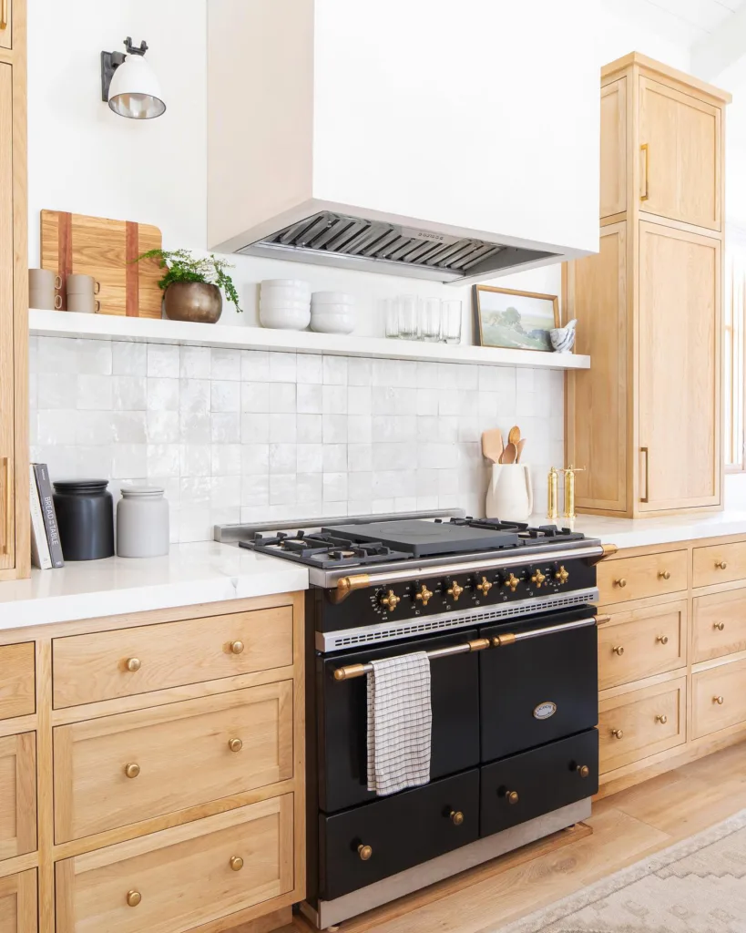 White tile and black oven with white oak cabinets