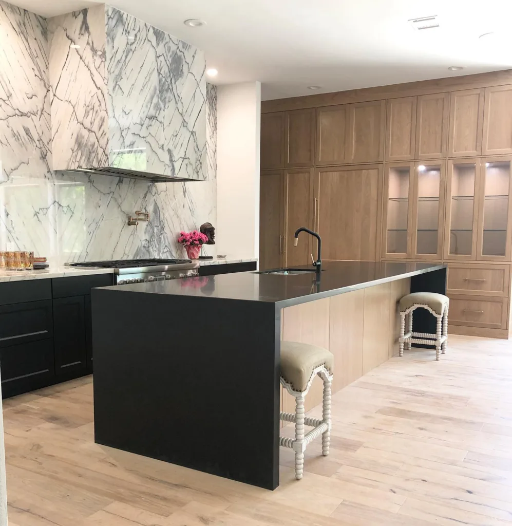 marble range and backsplash with oak cabinets