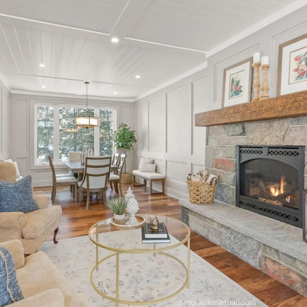 Stone fireplace and a white shiplap ceiling in a dining room