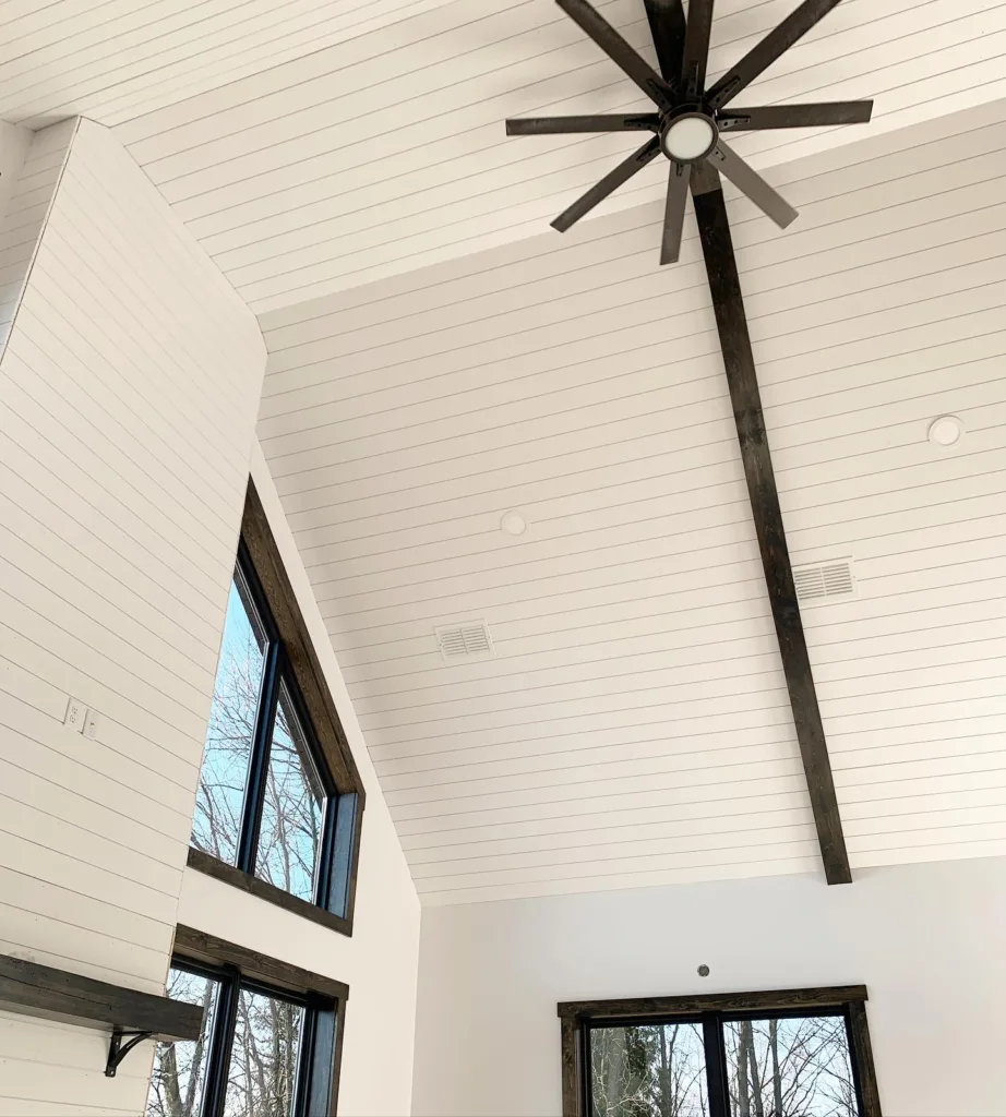 Tall vaulted ceiling with white shiplap and a large brown fan