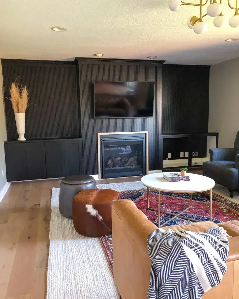 Black Accent Wall With Wood Trim In A Colorful Living Room With A Fireplace And Tv