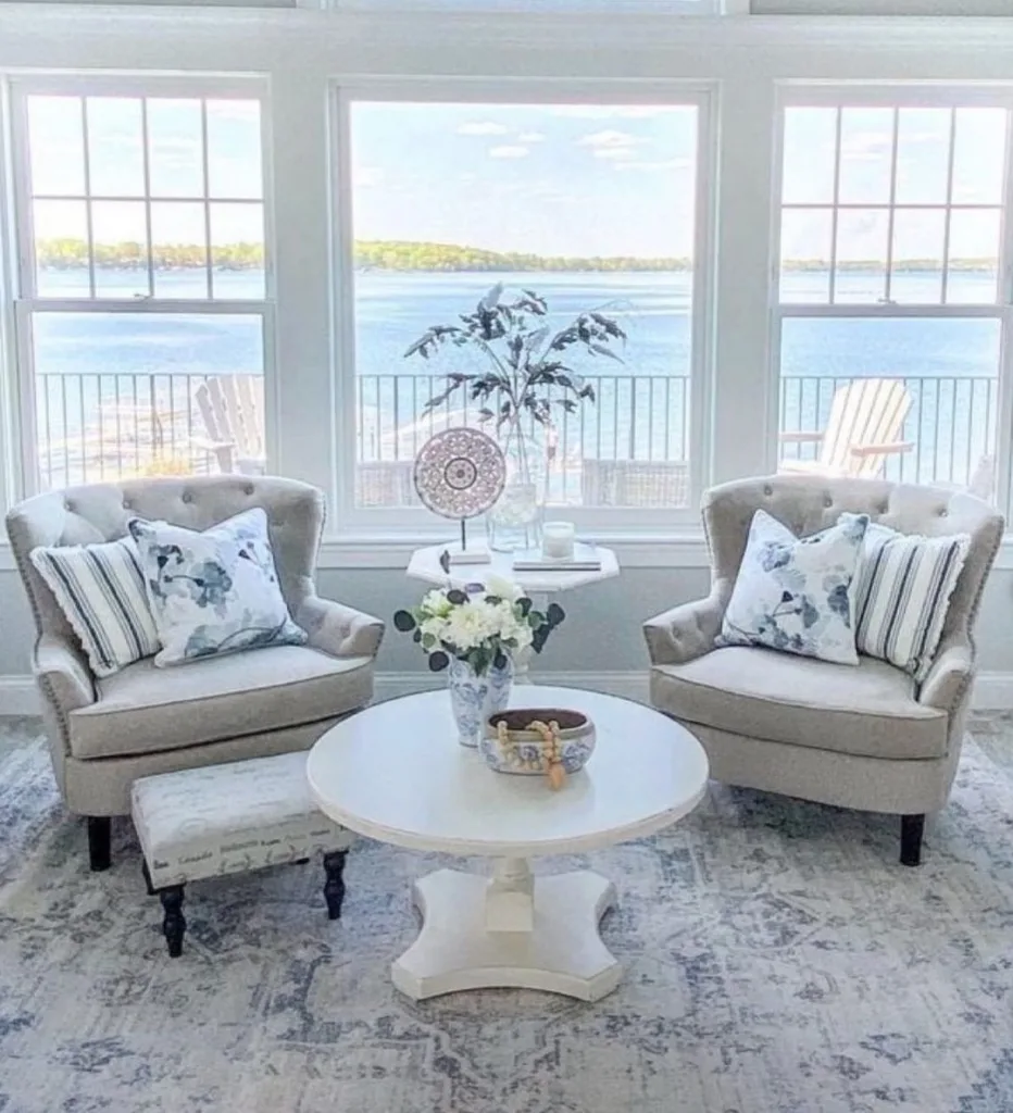 31 Coastal Beach-Themed Living Room Ideas 10 Two Beige Accent Chairs With Large Windows Behind Them That Face The Ocean