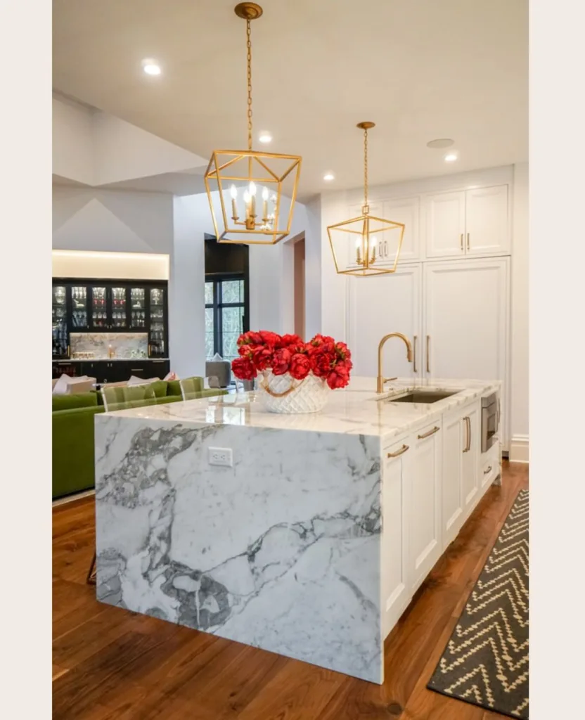 A White Waterfall Marble Countertop Island In A White And Gold Kitchen
