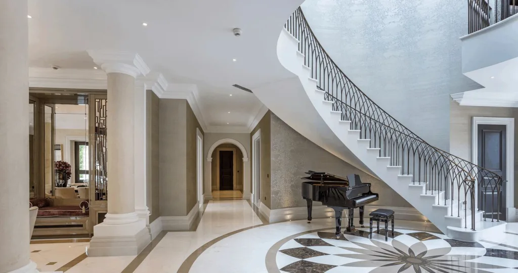 24 Curved Staircases For Design And Decor Inspiration 23 A Curved Staircase In An Entryway With Polished Tile Floor And A Baby Grand Piano