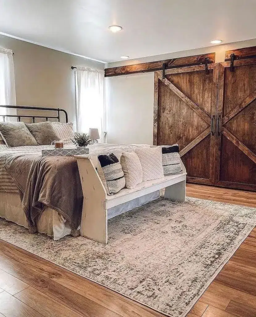 Farmhouse Bed With A Rug Underneath And A Sliding Barn Door In The Background