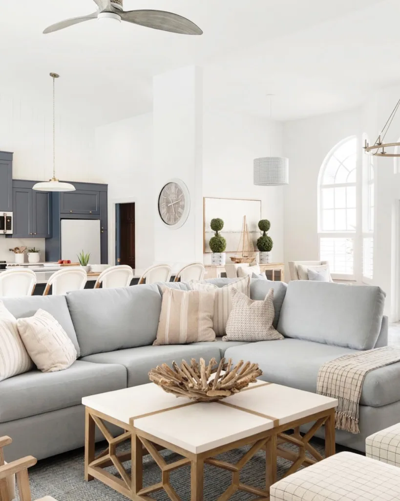 31 Coastal Beach-Themed Living Room Ideas 25 A Light Grey Sofa With Neutral Furniture Accents In A White Coastal Living Room