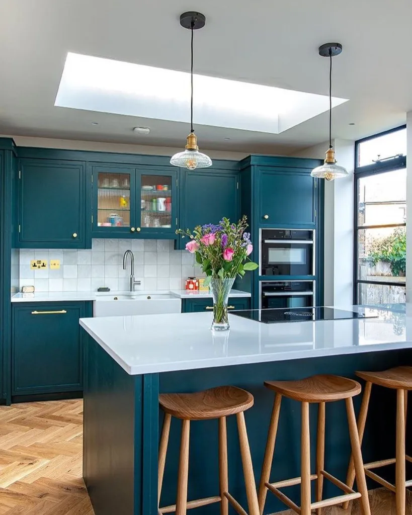 A Teal Kitchen With Chevron Wood Floors And A Teal Island With Seating