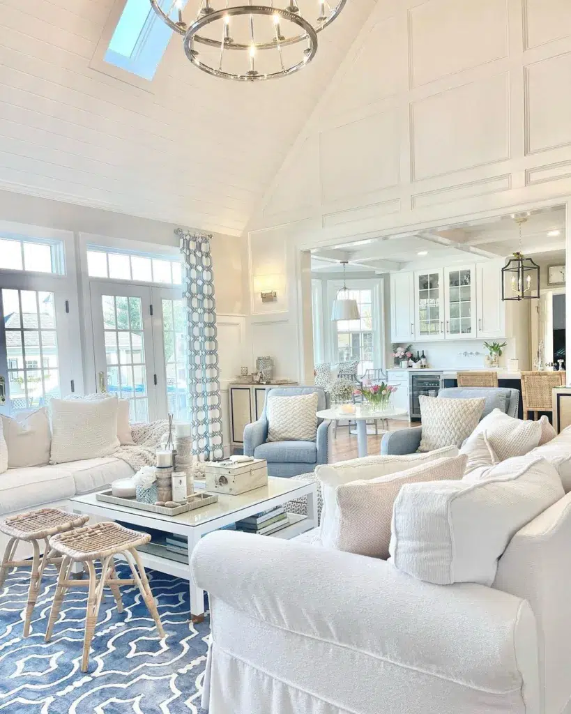 A Two Story Vaulted Ceiling Living Room With White And Blue Furniture In A Beach House