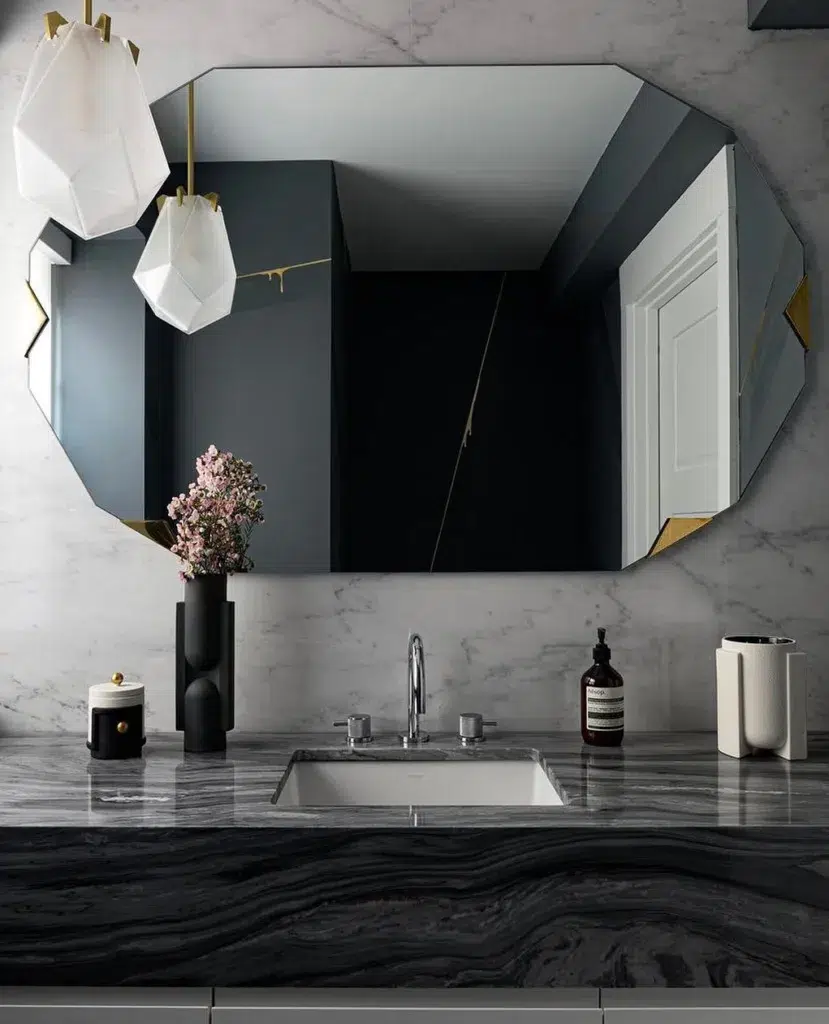 35 Bathroom Counter Decor Ideas 21 A Black Marble Vanity With A Matte Black Vase And Soap As Decor In Front Of The Mirror