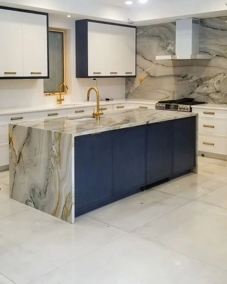An Elegant And Modern Kitchen With A Stunning Waterfall Countertop Made Of White Marble