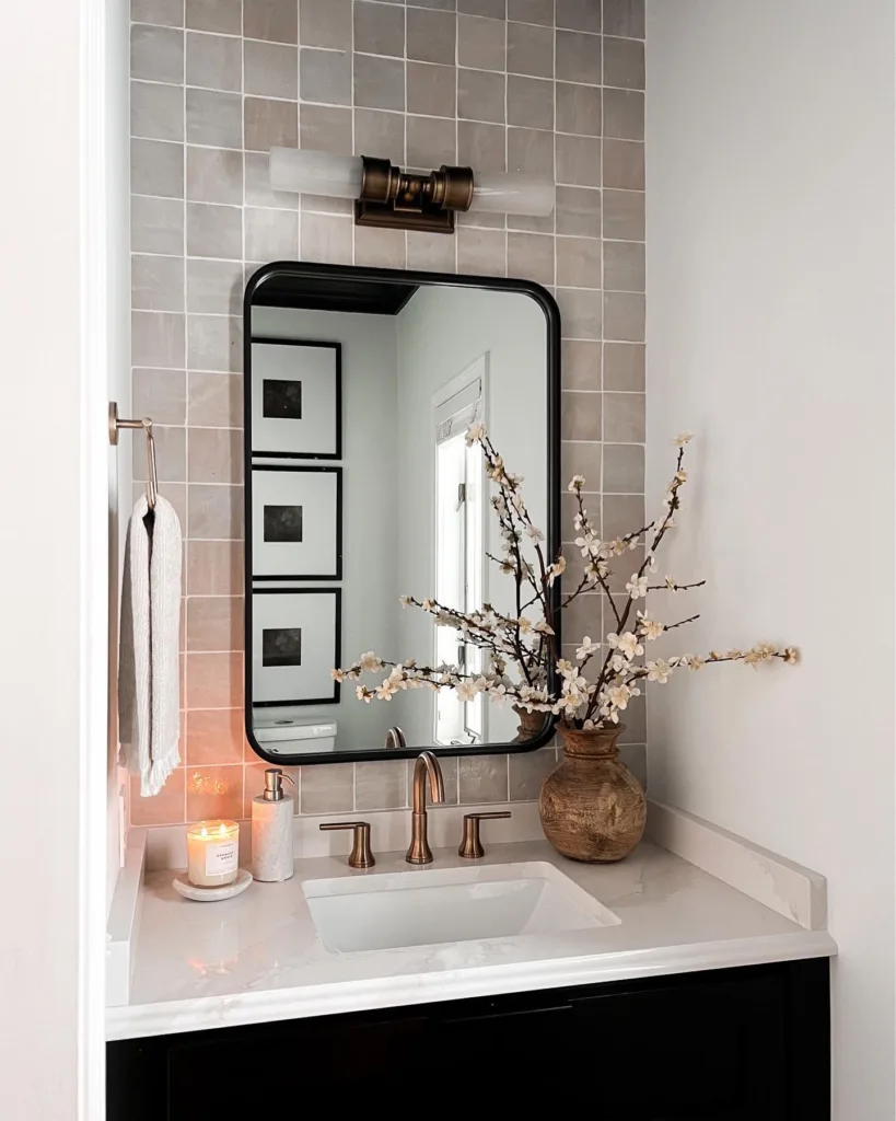 A Black Bathroom Vanity With White Countertop And A Wood Vase With Long Twigs As Decor