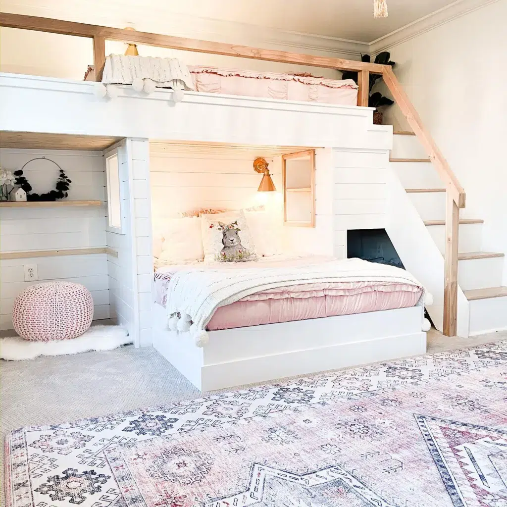 A White Shiplap Bedroom With A Bunk Bed Loft And Matching Sheets On Both Beds