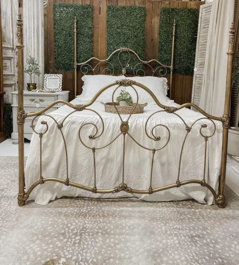 A Gold Frame Bed With White Sheets And A Beige Rug Under The Bed