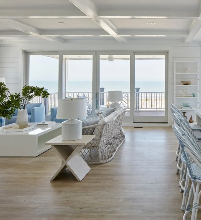 A Beach Living Room With Large Sliding Doors Leading To A Balcony From The Living Room With Blue Accents