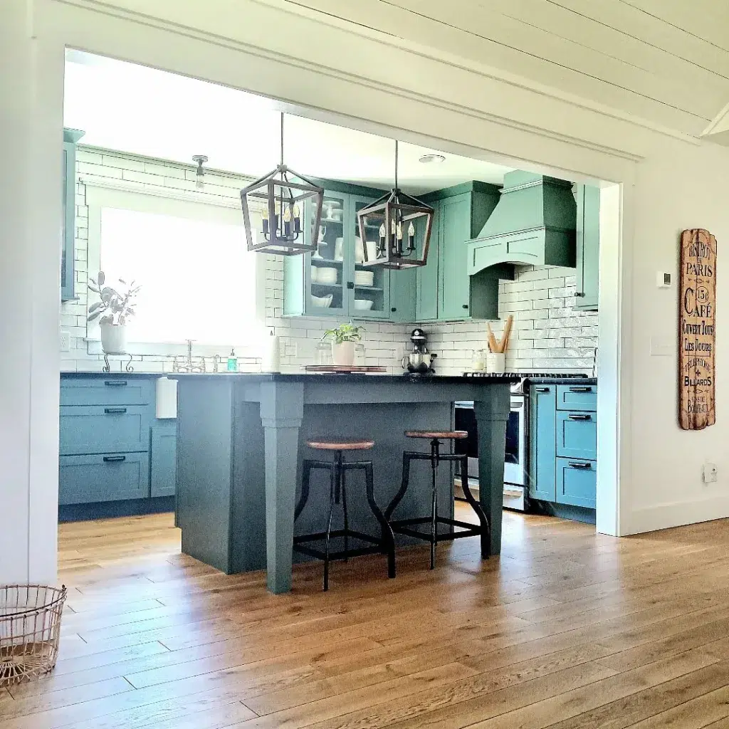 A Country Kitchen With Teal Green Upper Cabinets And Blue Lower Cabinets