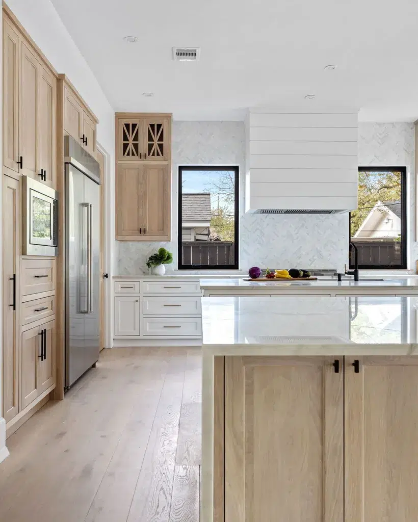 White Oak Kitchen Cabinets Next To Two Islands One Of Which Has A Waterfall Countertop. 