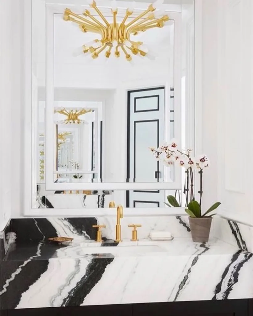 35 Bathroom Counter Decor Ideas 31 A Black And White Marble Vanity With A Plant As Decor For A Pop Of Color