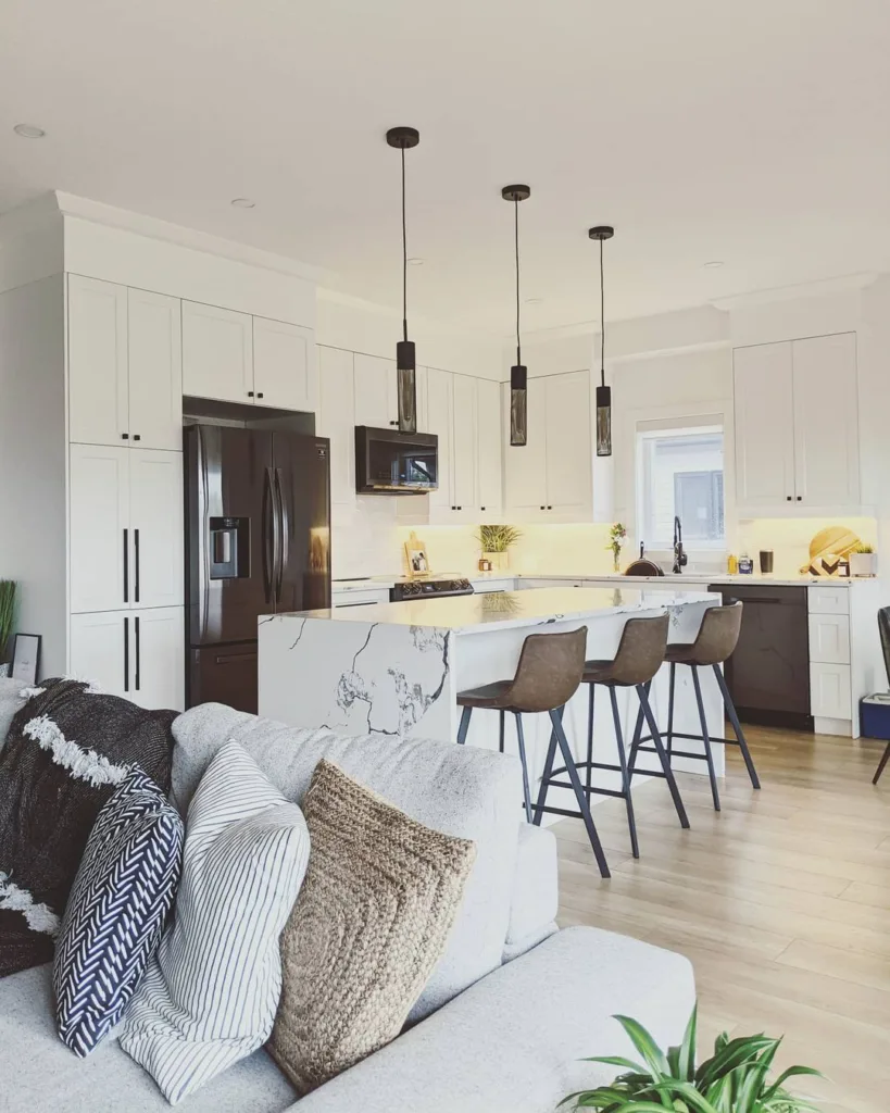 32 Waterfall Kitchen Island Ideas For Inspiration 7 A White Kitchen With Floor-To-Ceiling Cabinets And A White Marble Countertop Island