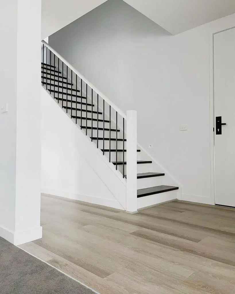 White Staircases With Black Treads In A Farmhouse Home