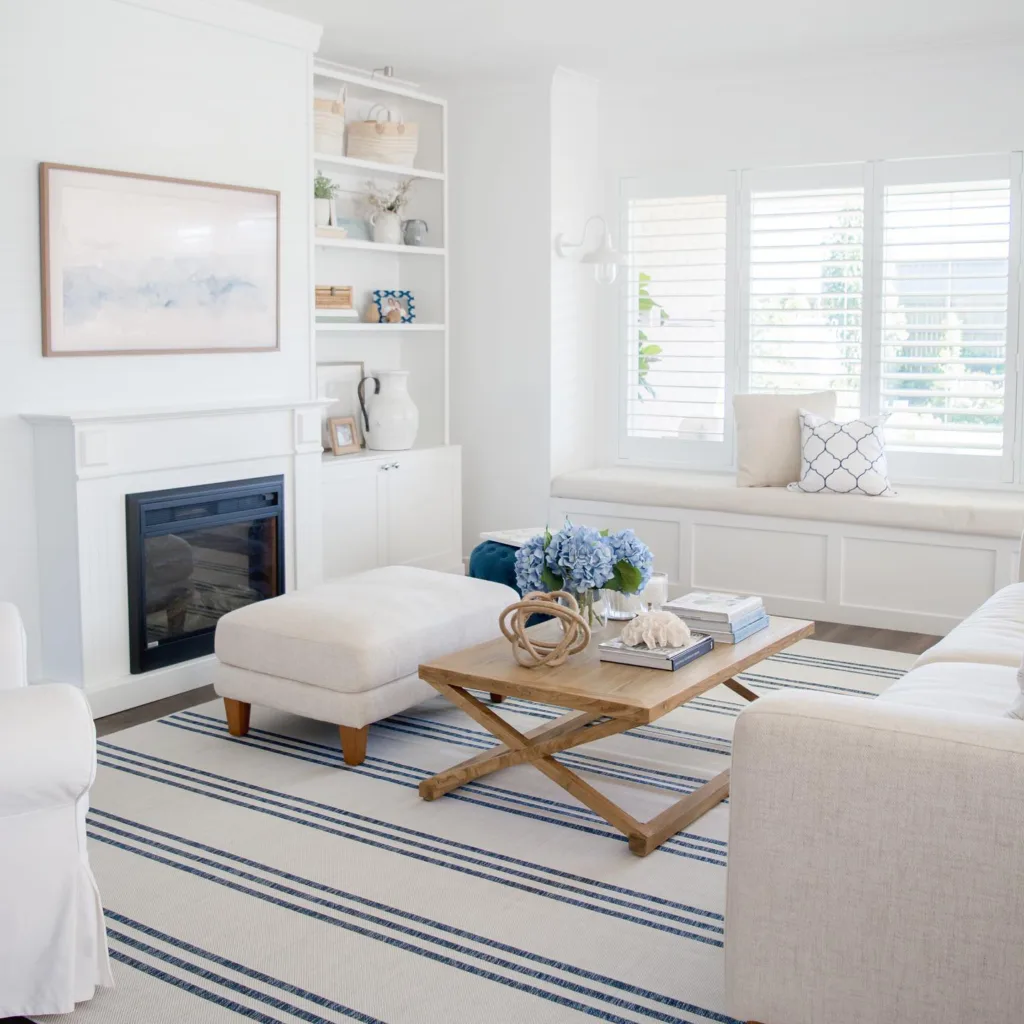 31 Coastal Beach-Themed Living Room Ideas 31 Light Grey Furniture And A Wood Coffee Table On A White And Blue Striped Rug In A Living Room