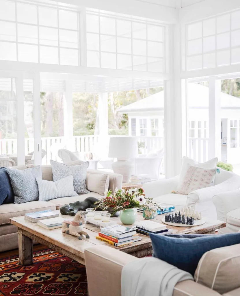 31 Coastal Beach-Themed Living Room Ideas 17 A White Living Room With Lots Of Windows And Natural Light And Beige Sofas