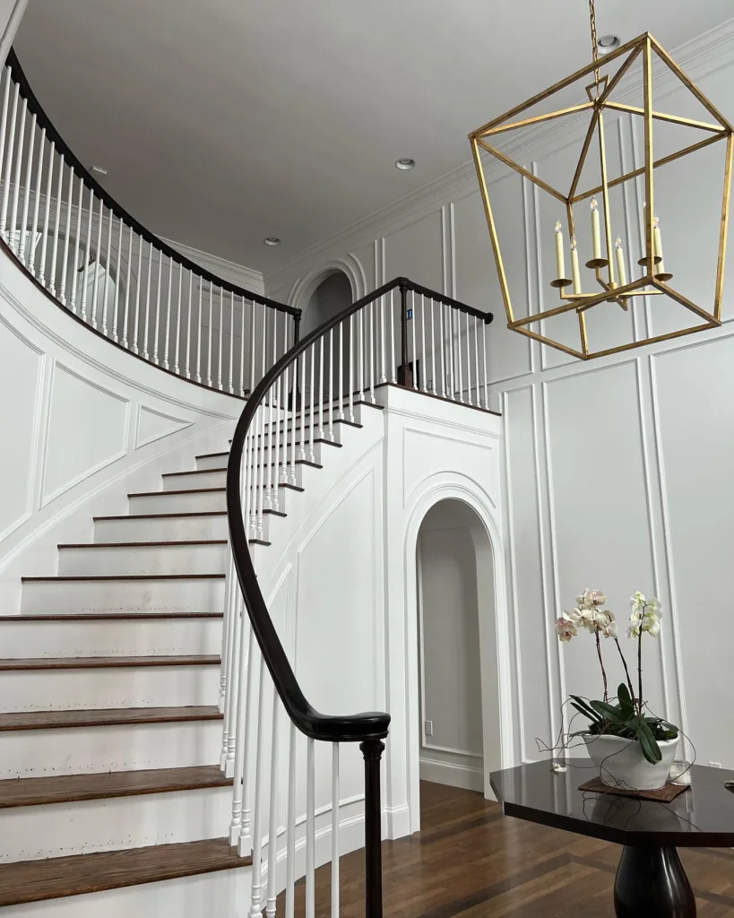 An Entryway with a black and white curved Staircase