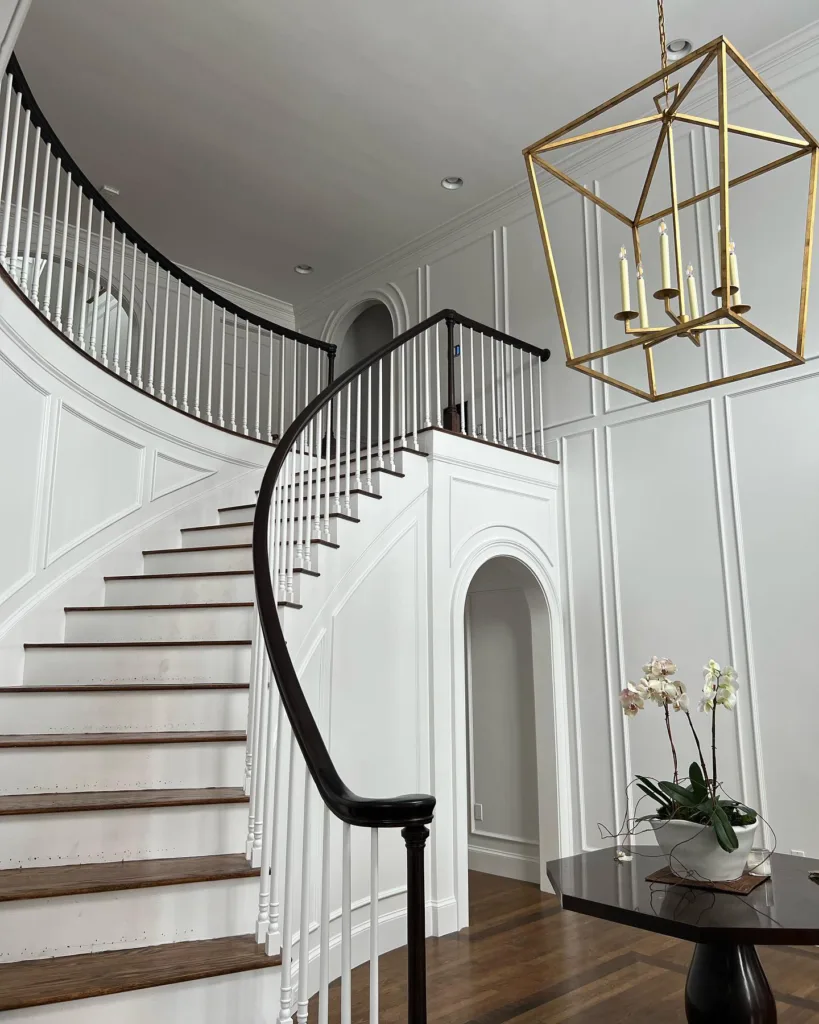 24 Curved Staircases For Design And Decor Inspiration 24 A Curved Staircase In A White Entryway With Brown Treads That Match The Brown Wood Floors In The Room
