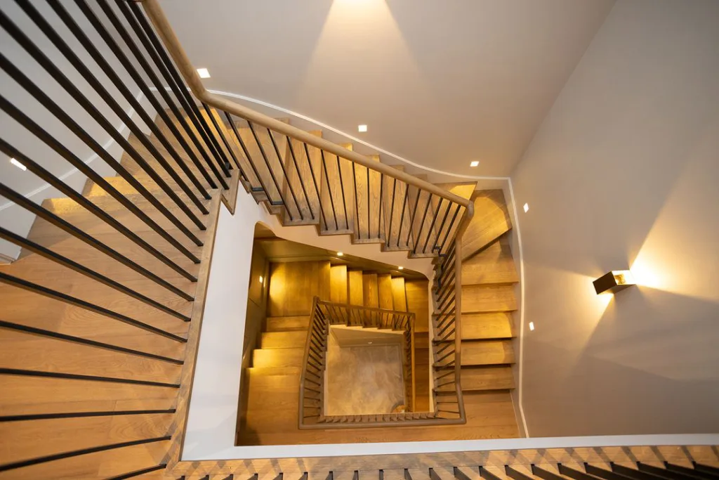 A Multi Floor Staircase Is Lit By A Stunning Chandelier Hanging From The Ceiling Above