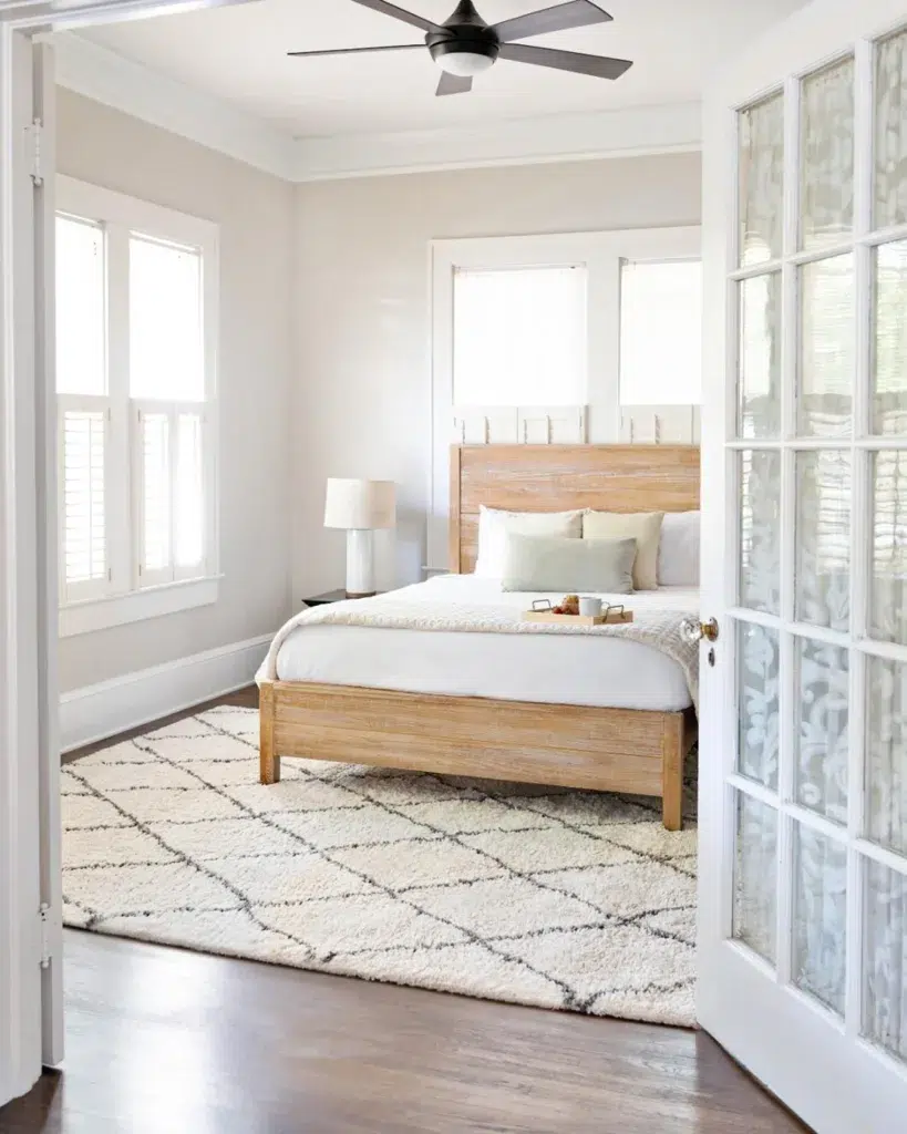 37 Rug Under Bed Ideas For A Stylish Bedroom 14 A White Rug With Thin Black Stripes Below A Wood Bed With White Bedding
