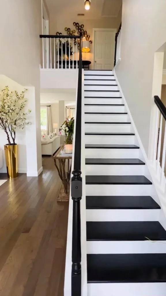 Painted Black Stairs With White Railing And The Black Handle In A Room With Plain White Walls
