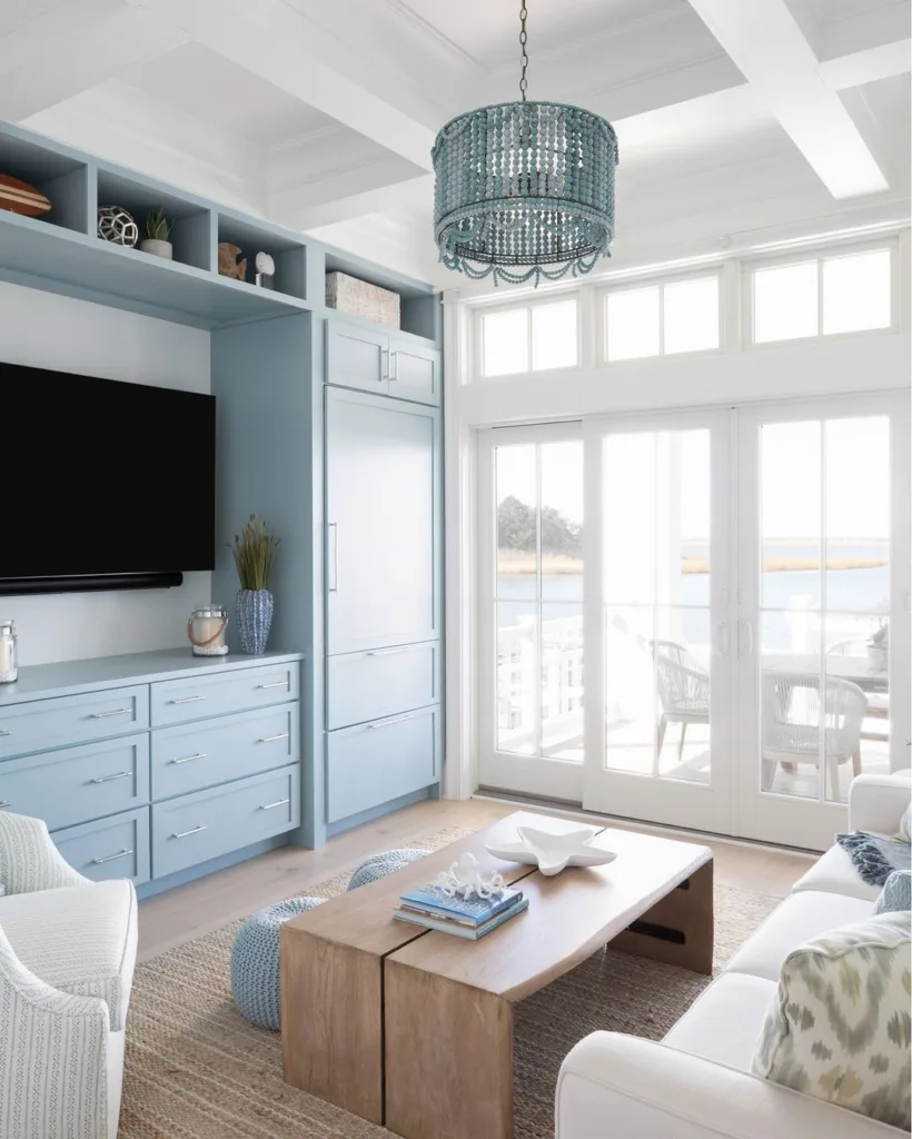 Light Blue Cabinets Around The Tv In A Beach Themed Living Room With A White Sofa And Wood Coffee Table