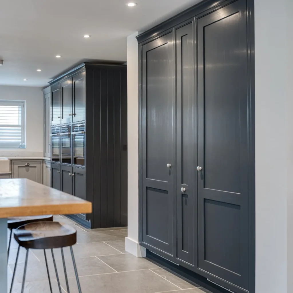 Appliances Built-Into Dark Blue Floor-To-Ceiling Cabinets
