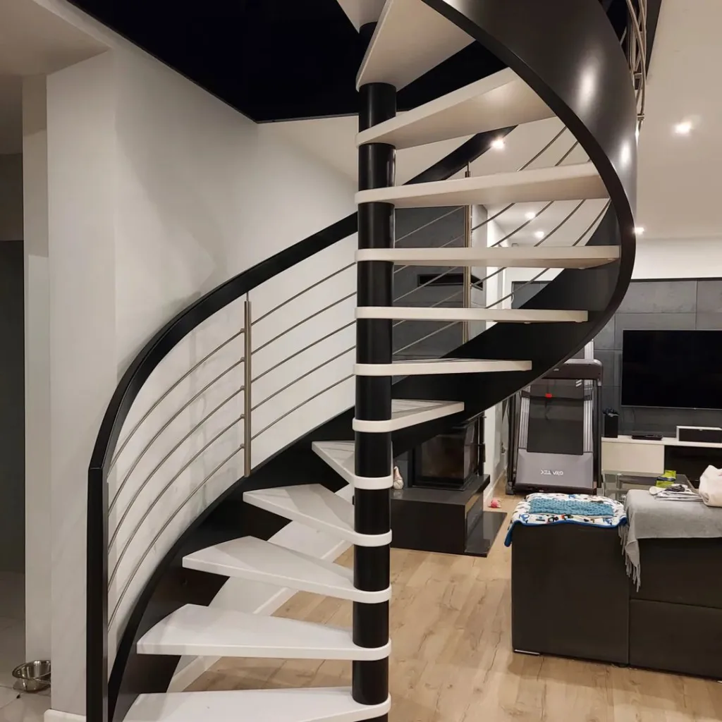 Spiral Design Black And White Stairs. Silver Railing With Black Handle And White Steps In A Room With White Walls