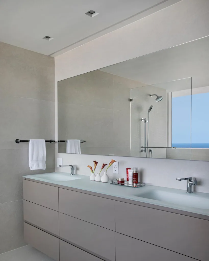 35 Bathroom Counter Decor Ideas 34 A Beige Modern Bathroom Vanity With Three Small White Vases And A Polished Silver Tray With Soap As Decor