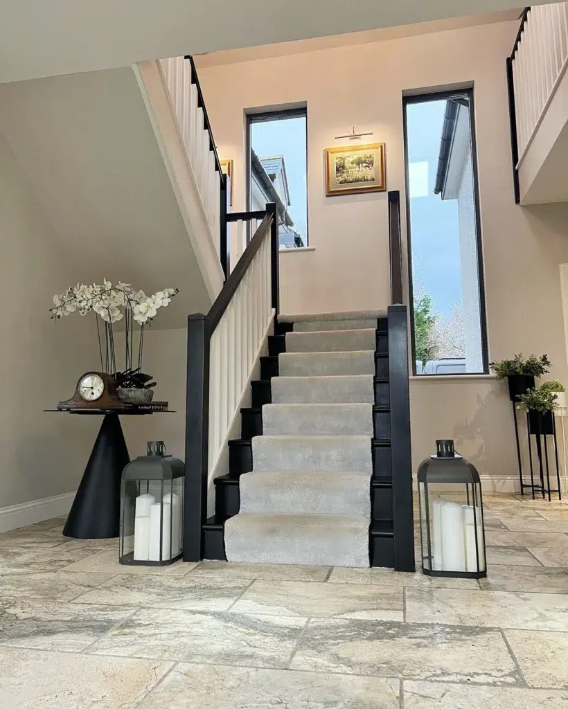 Black Stairs With White Spindles And A Grey Runner In A Two-Story Entryway