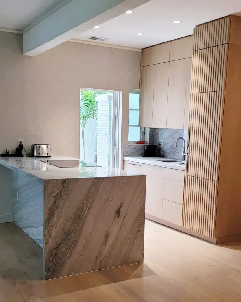 32 Waterfall Kitchen Island Ideas For Inspiration 5 A Waterfall Edge Granite Countertop Near Natural Wood Cabinets