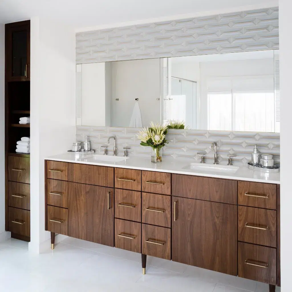35 Bathroom Counter Decor Ideas 18 A Brown Wood Vanity With A Vase Of Flowers As Decor Between The Two Sinks