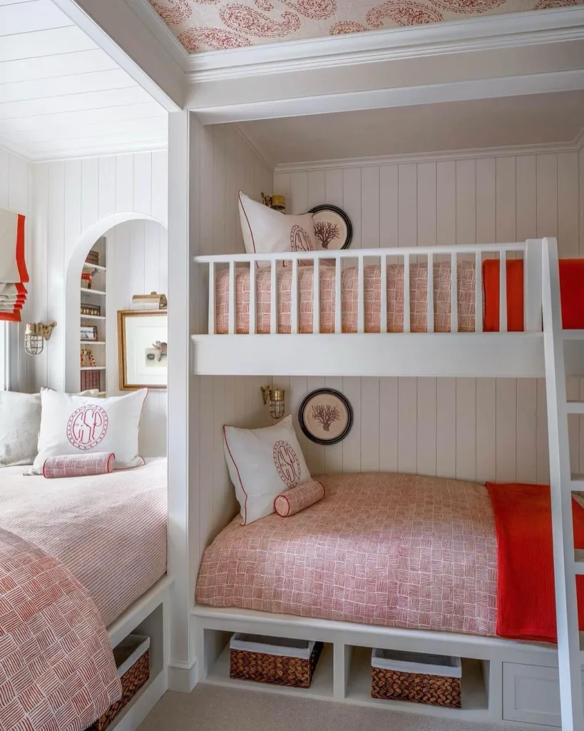 A Girls Room With Two Bunk Beds Built-Into The Wall With Vertical Shiplap And Pink Bedding