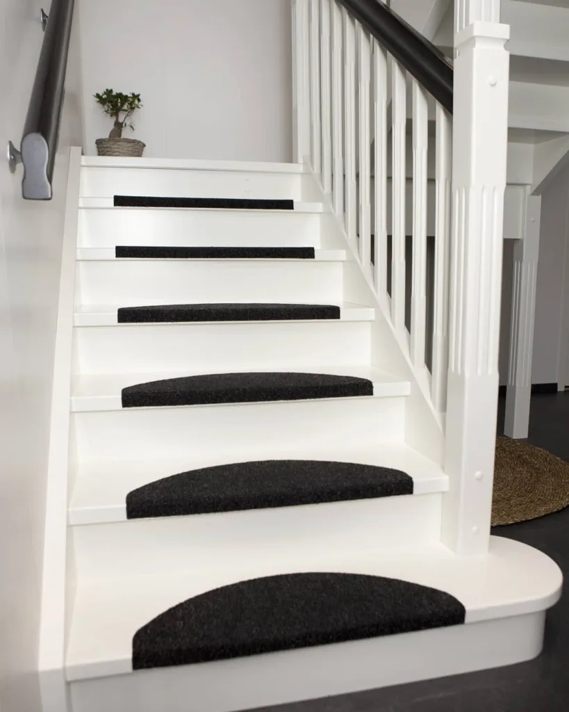 White Stairs With Black Accents In A Room With Black Floors