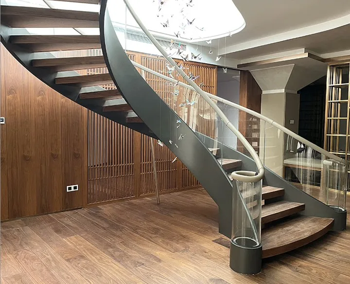 Glass Sides On A Metal And Wood Curved Staircase Leading To A Room With Wood Floors