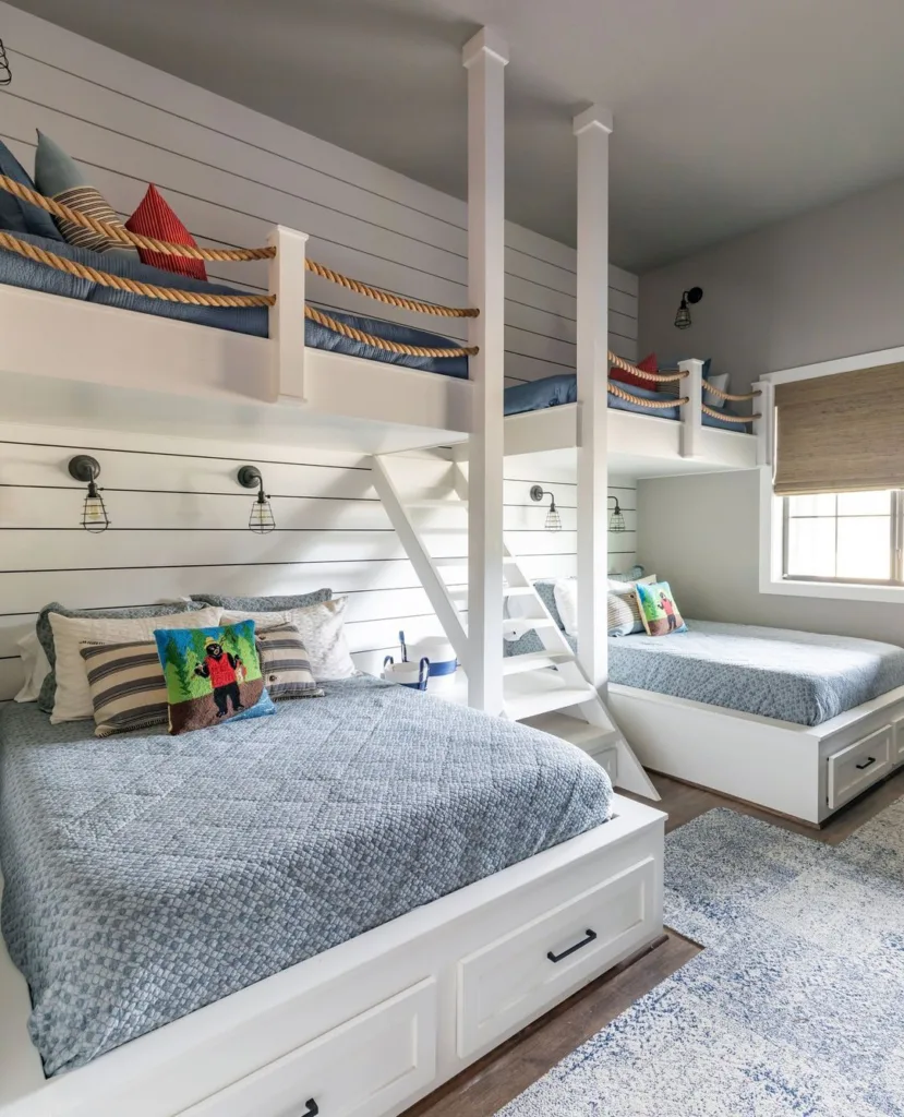 A Nautical Themed Built-In Bunk Bed With Rope Railings And White Shiplap Accent