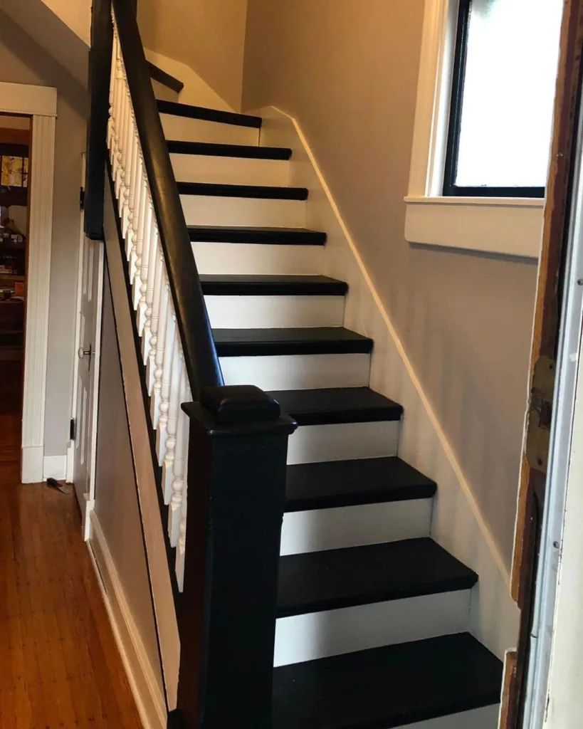 A Narrow Staircase With Black Treads And White Risers 