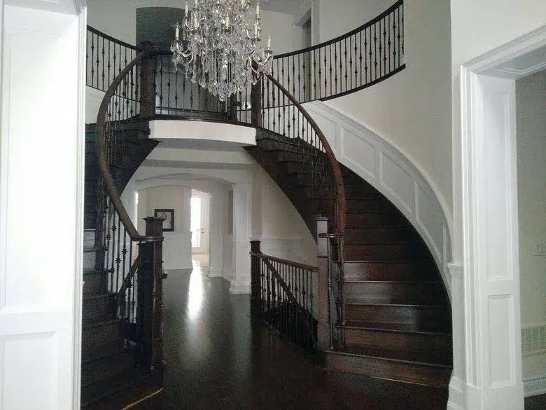 24 Curved Staircases For Design And Decor Inspiration 13 Double Curved Staircases With Dark Brown Treads And Risers And A Chandelier In The Center Of The Room
